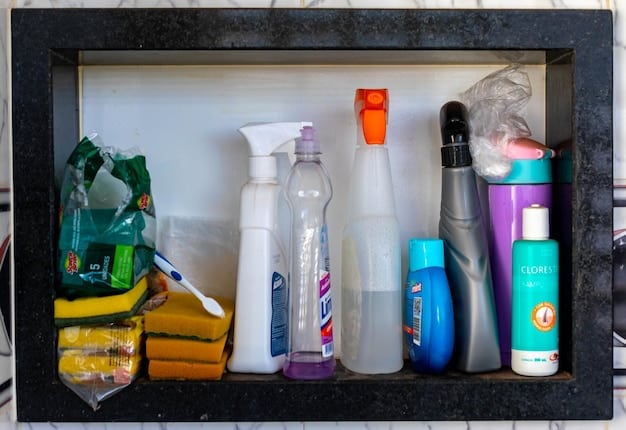 A well-organized cleaning supply cabinet under a sink. Various glass spray bottles and jars are visible, filled with homemade cleaning solutions. Labels are neatly affixed to each container, indicating the contents, such as 