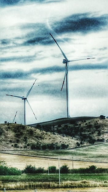 A split image showing a wind farm on one side and a carbon capture facility on the other, symbolizing the diverse impact of the Inflation Reduction Act on both renewable energy generation and carbon emissions reduction technologies.