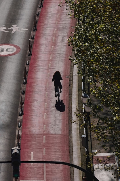 An image showcasing a person riding a bicycle on a dedicated bike path through a lush urban park. The cyclist should appear happy and healthy, wearing comfortable clothing and a helmet. The background should feature a mix of greenery, walking paths, and other cyclists, creating a vibrant and active scene.