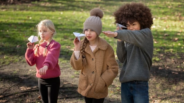 A group of children and adults at a community workshop learning about bear safety, with a park ranger demonstrating the proper use of bear spray.